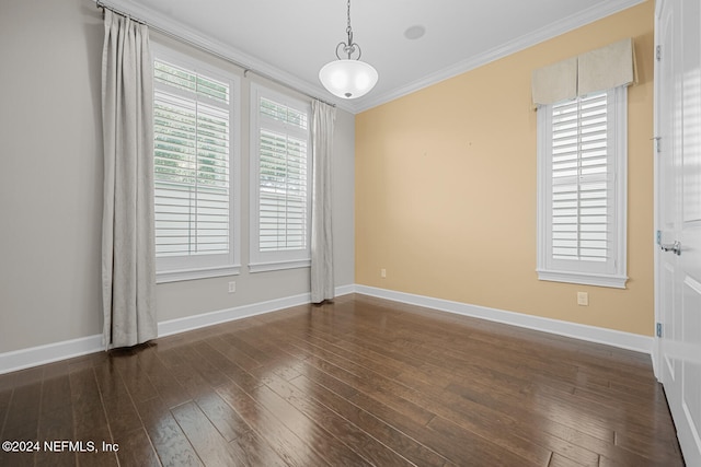 spare room featuring dark hardwood / wood-style flooring and crown molding