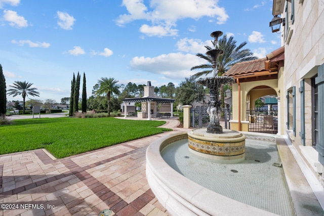 view of property's community with a yard and a pergola