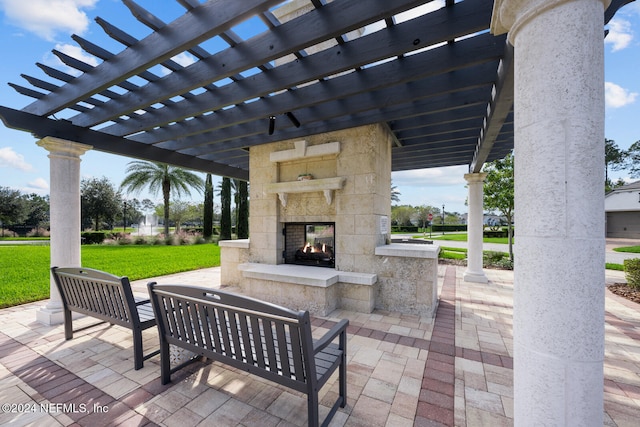 view of patio / terrace with an outdoor living space with a fireplace and a pergola