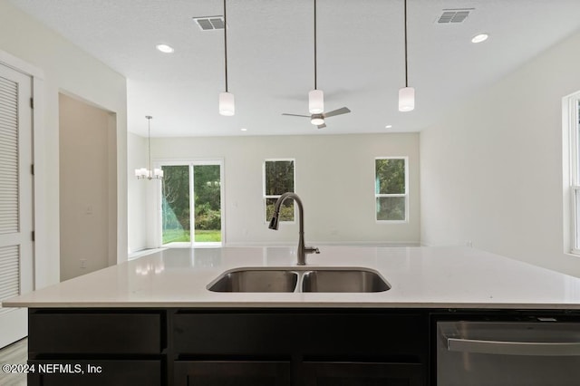 kitchen with ceiling fan with notable chandelier, hanging light fixtures, sink, an island with sink, and stainless steel dishwasher