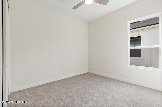 spare room featuring light colored carpet and ceiling fan