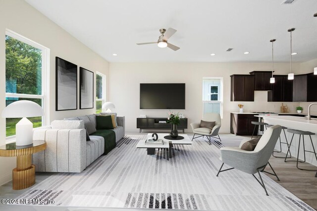 living room with light wood-type flooring and ceiling fan