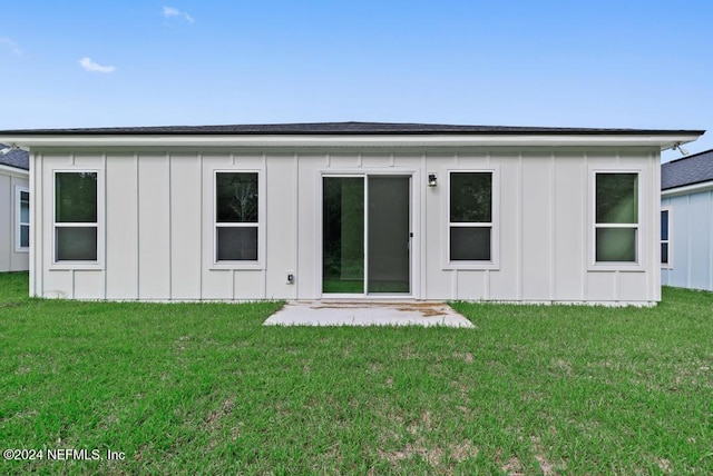 rear view of property featuring a yard