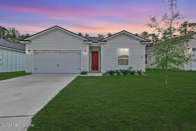 single story home with a garage and a yard