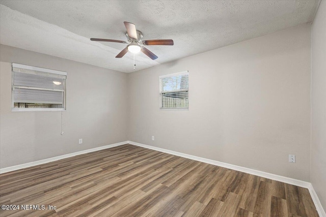 spare room featuring ceiling fan, wood-type flooring, and a textured ceiling