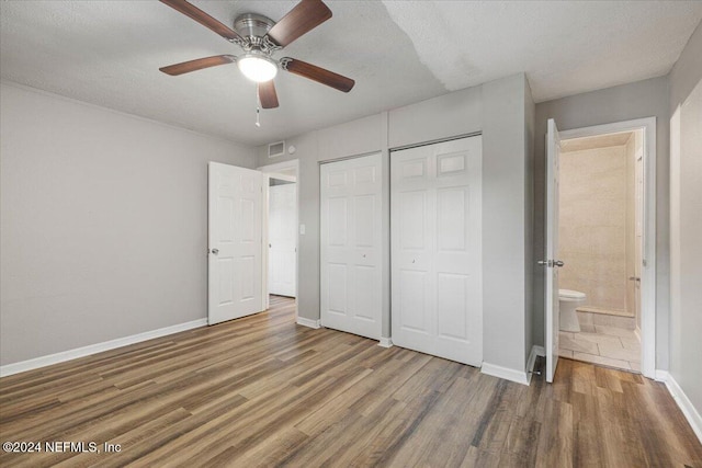 unfurnished bedroom featuring ceiling fan, dark hardwood / wood-style flooring, a textured ceiling, and a closet