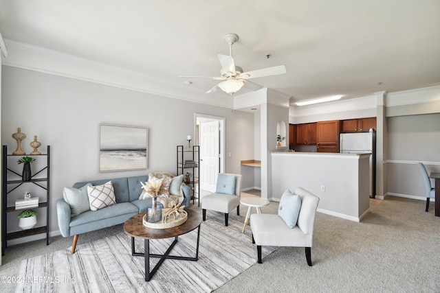 carpeted living room with ornamental molding and ceiling fan