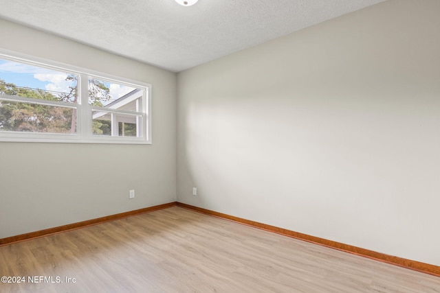 empty room featuring light hardwood / wood-style flooring and a textured ceiling