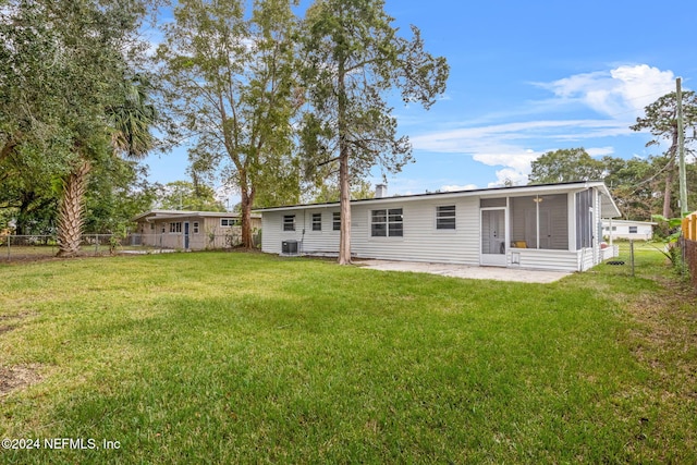 rear view of house with a patio area, a sunroom, a yard, and cooling unit