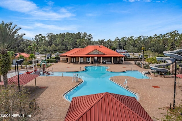 view of swimming pool with a patio and a water slide