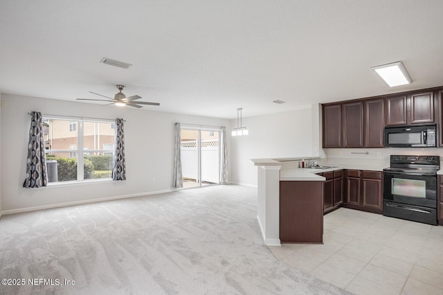 kitchen with plenty of natural light, kitchen peninsula, light carpet, and black appliances