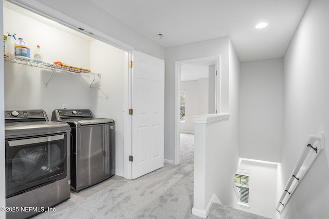 washroom featuring independent washer and dryer, a healthy amount of sunlight, and light carpet