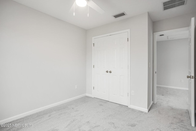 unfurnished bedroom featuring ceiling fan, light colored carpet, and a closet