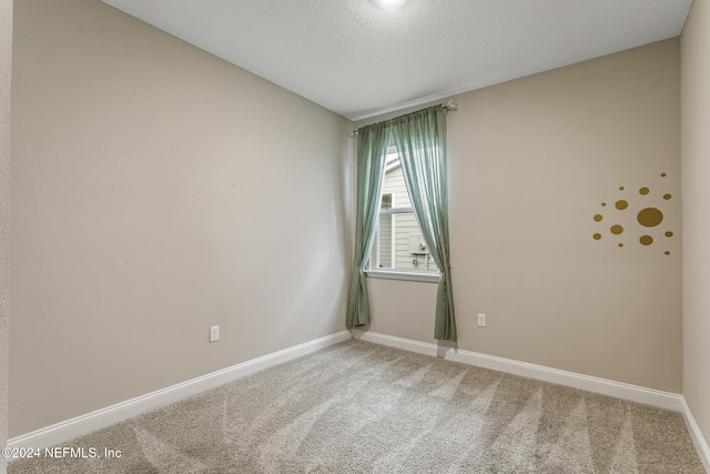 carpeted empty room featuring a textured ceiling