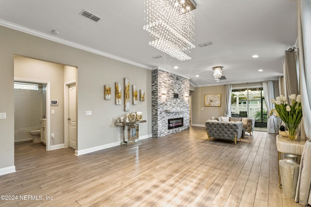 living room featuring a stone fireplace, light wood-type flooring, and ornamental molding