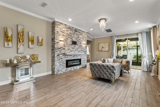 living room with a fireplace, light hardwood / wood-style flooring, lofted ceiling, and crown molding