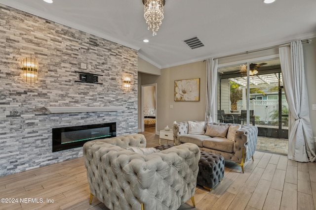 living room with ornamental molding, vaulted ceiling, light hardwood / wood-style floors, and a fireplace