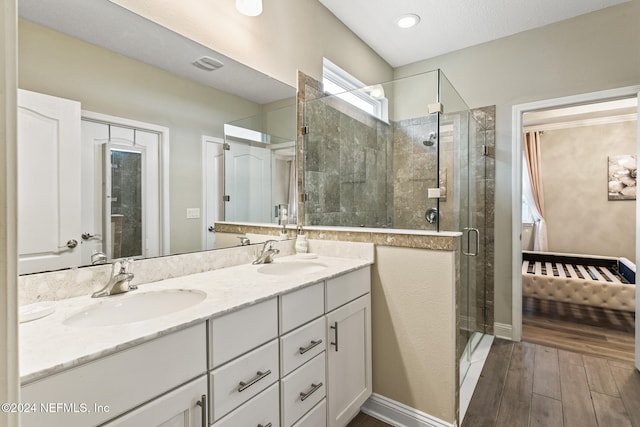 bathroom featuring hardwood / wood-style flooring, vanity, and walk in shower