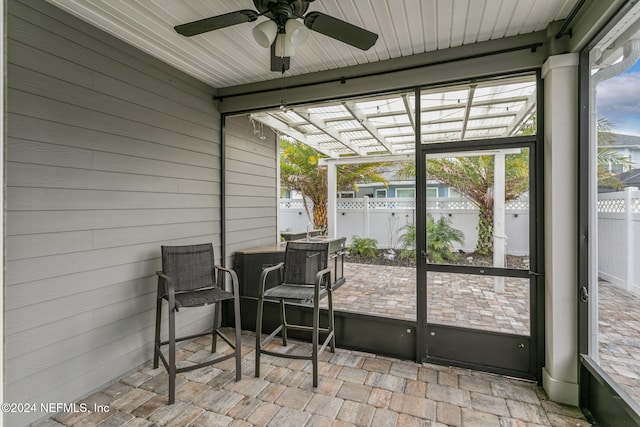 sunroom featuring ceiling fan and plenty of natural light