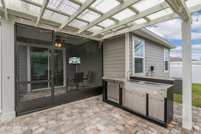 view of patio with sink, a pergola, and exterior kitchen