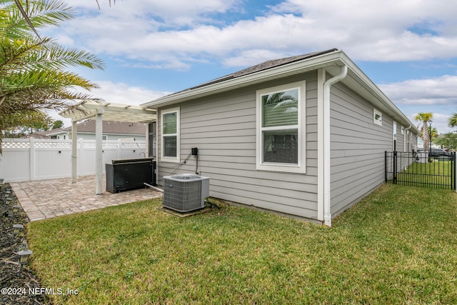 back of house with central air condition unit, a patio, and a yard