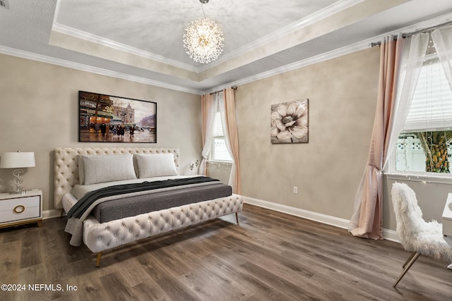 bedroom featuring dark wood-type flooring, a tray ceiling, an inviting chandelier, and crown molding