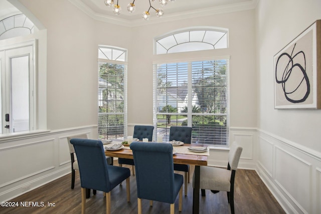 dining area featuring dark hardwood / wood-style floors, an inviting chandelier, and ornamental molding