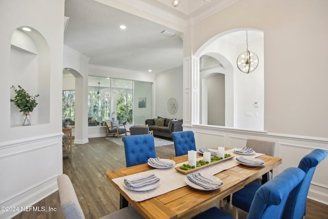 dining room featuring dark wood-type flooring, a chandelier, and crown molding