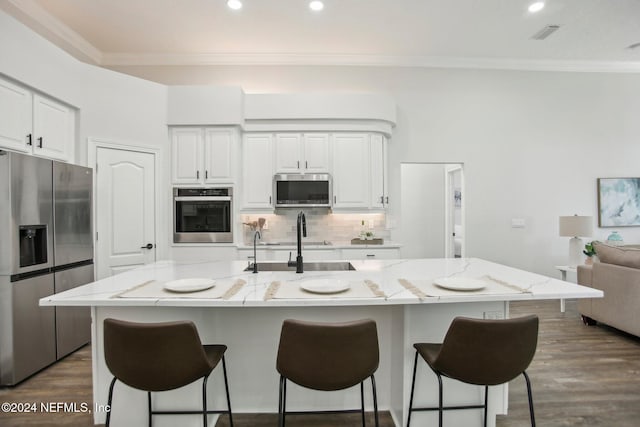 kitchen featuring stainless steel appliances, white cabinetry, and a spacious island