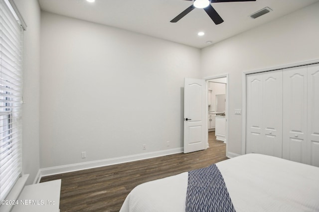 bedroom featuring ceiling fan, dark hardwood / wood-style floors, and a closet