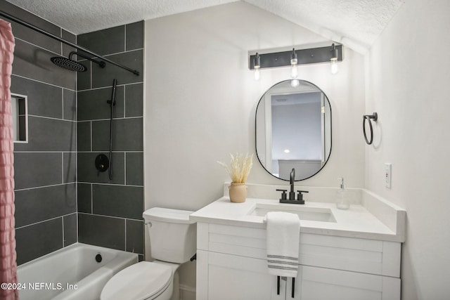 full bathroom featuring toilet, tiled shower / bath combo, vanity, and a textured ceiling