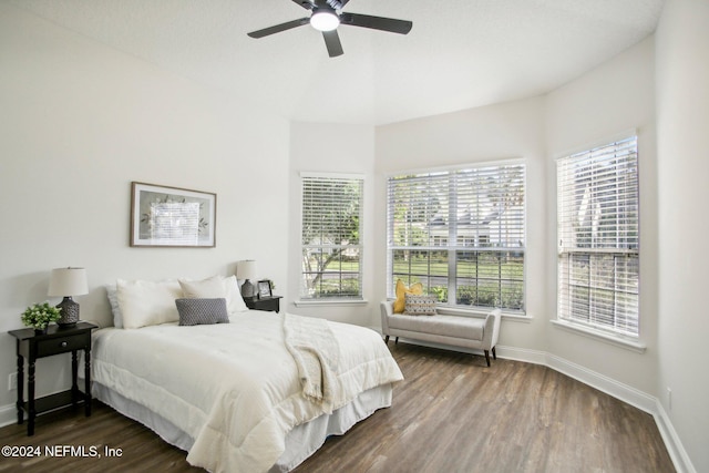 bedroom featuring dark hardwood / wood-style flooring, multiple windows, and ceiling fan