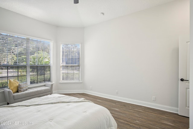 bedroom featuring ceiling fan, a textured ceiling, and dark hardwood / wood-style flooring