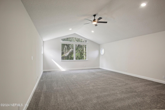 bonus room featuring ceiling fan, dark colored carpet, a textured ceiling, and vaulted ceiling