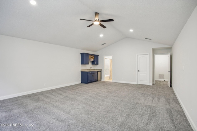 unfurnished living room featuring ceiling fan, vaulted ceiling, and carpet floors