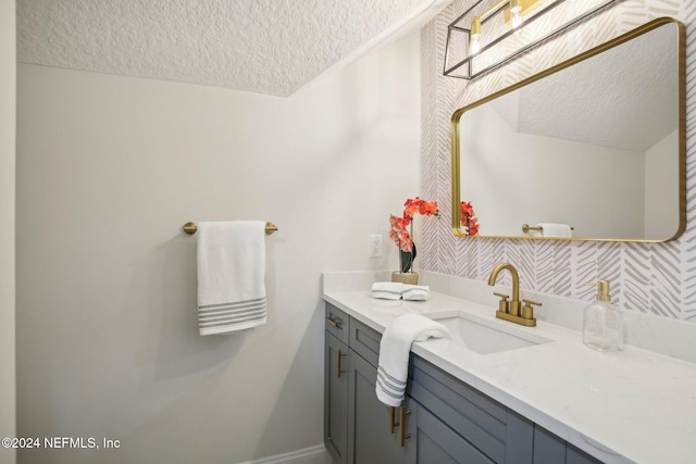 bathroom with decorative backsplash, vanity, and a textured ceiling