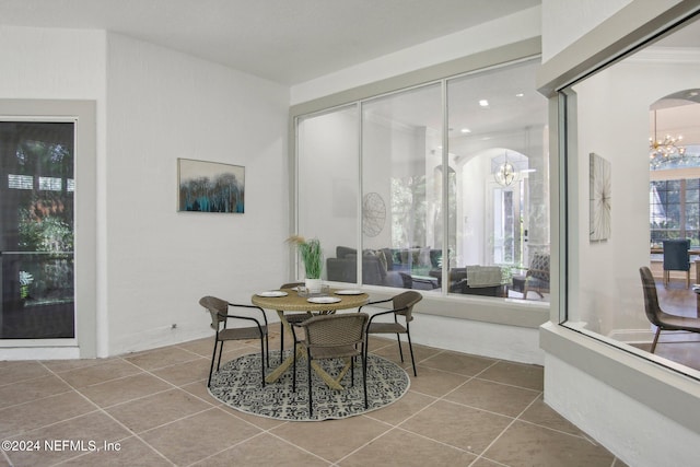 dining area with tile patterned floors and an inviting chandelier