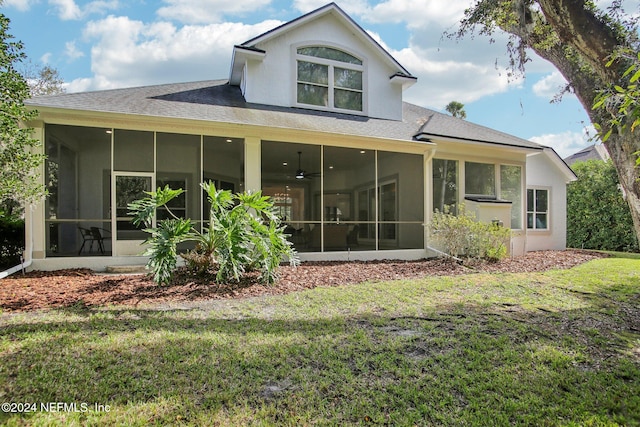 rear view of property featuring a sunroom and a yard