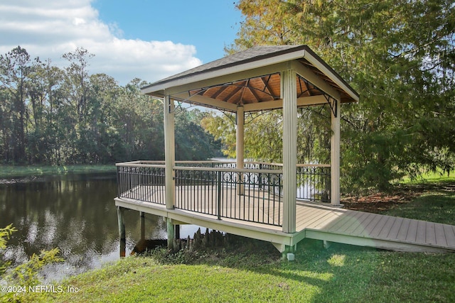 view of dock featuring a lawn, a deck with water view, and a gazebo