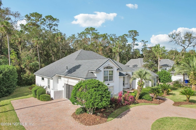 view of front of property featuring a garage and a front lawn