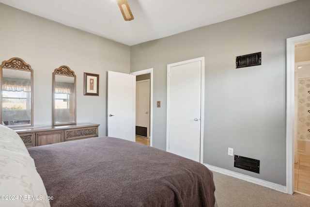 bedroom featuring ensuite bathroom, light carpet, and ceiling fan