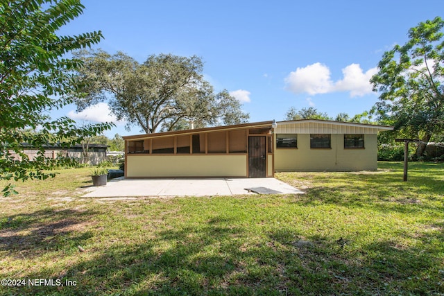 back of house with a patio and a yard