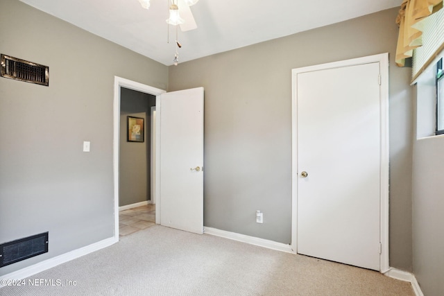 unfurnished bedroom featuring ceiling fan and light carpet