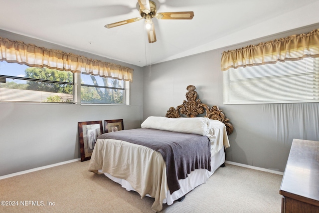 bedroom with multiple windows, light carpet, and ceiling fan