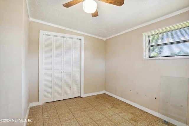 unfurnished bedroom featuring ornamental molding, ceiling fan, a textured ceiling, lofted ceiling, and a closet