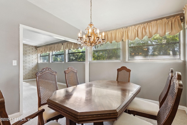 carpeted dining area featuring lofted ceiling and a notable chandelier