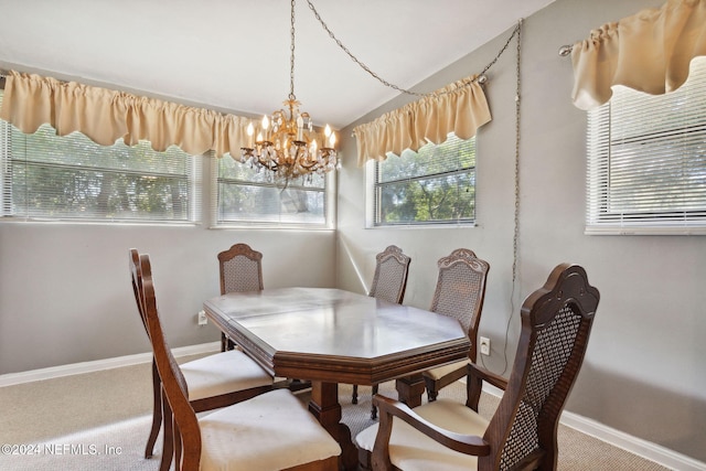 carpeted dining area with a chandelier and vaulted ceiling