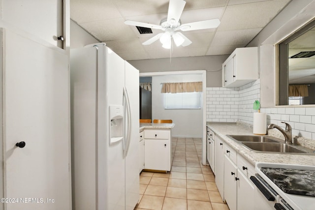 kitchen featuring tasteful backsplash, white cabinetry, white fridge with ice dispenser, sink, and a drop ceiling