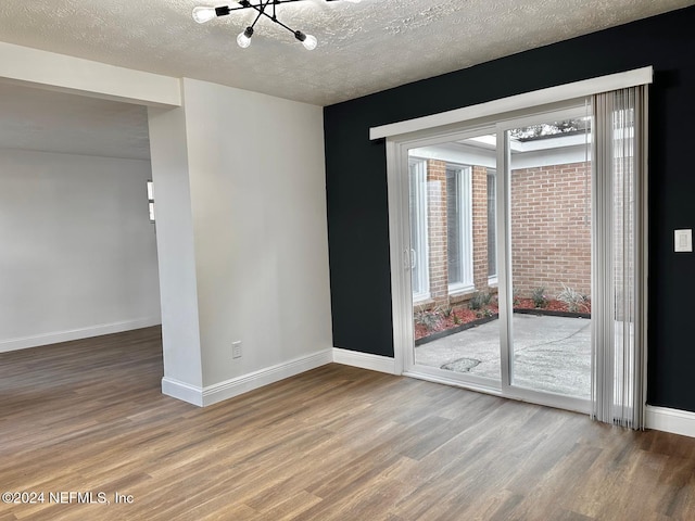 spare room with a textured ceiling and hardwood / wood-style flooring