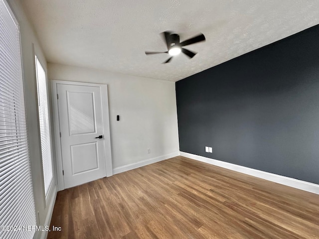 unfurnished room featuring ceiling fan, hardwood / wood-style floors, and a textured ceiling